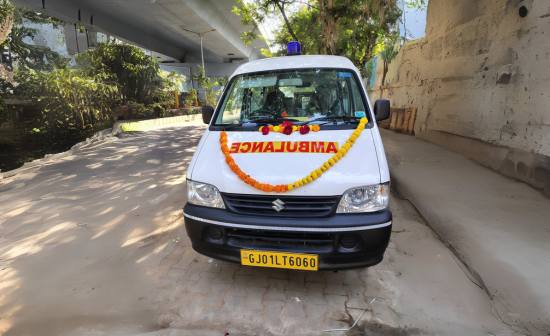 A white van adorned with a garland, symbolizing Kalyan Jivashray Foundation's ambulance service for injured animals.