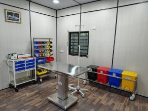 Interior of a hospital room with medical equipment and a bed, highlighting the modular operation theater by Kalyan Jivashray Foundation.