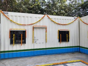 A white container house decorated with marigold garlands.