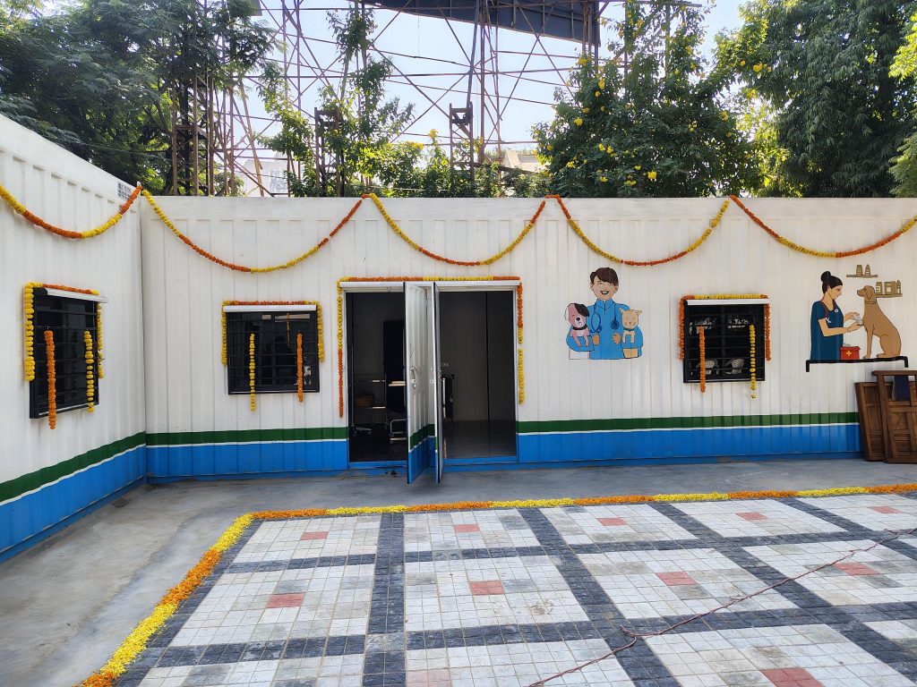 A white container house decorated with marigold garlands.